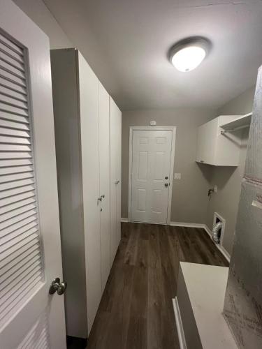 an empty room with a white door and a kitchen at Get cozy in this Renovated home by the Villages in Lady Lake