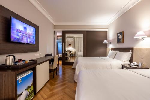 a hotel room with two beds and a flat screen tv at Wish Foz do Iguaçu in Foz do Iguaçu
