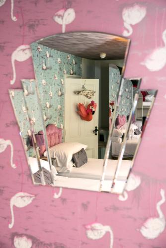 a mirror reflection of a bed in a pink room at Tide & Teacups in Brighton & Hove