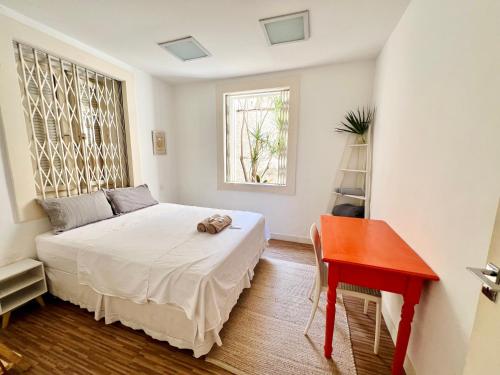 a bedroom with a bed and a desk and a window at Ap 19 de fevereiro in Rio de Janeiro