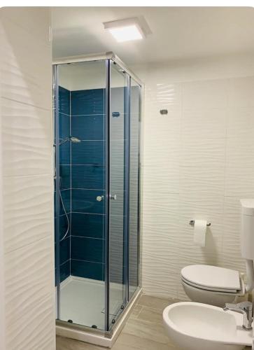 a bathroom with a toilet and a glass shower at Mazzini Home in Cosenza