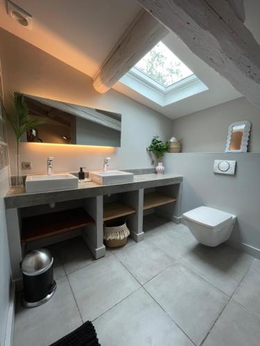 a bathroom with two sinks and a toilet at La Tuilerie du Bazalac in Trèbes