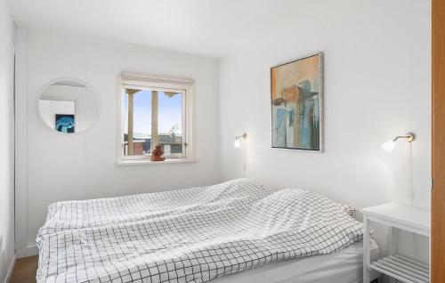 a white bedroom with a bed and a window at Nice Home In Øster Assels in Øster Assels
