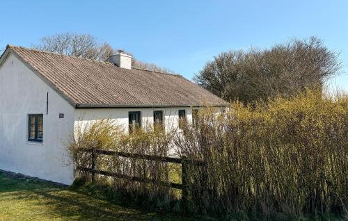 a white house with a brown roof and a fence at 1 Bedroom Gorgeous Home In Spøttrup in Spottrup