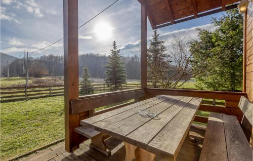 a wooden table on a porch with a view of a field at Lovely Home In Buzim With Sauna in Bužim