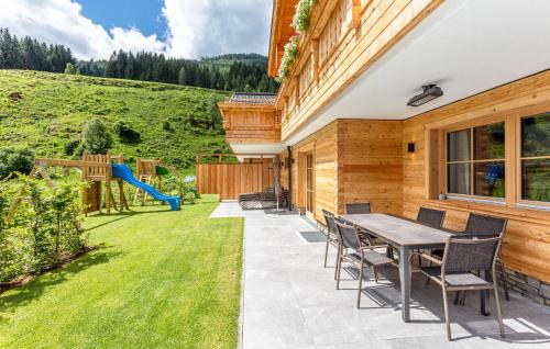 a patio with a table and chairs and a playground at Ferienhaus Großarl Mit Sauna in Grossarl