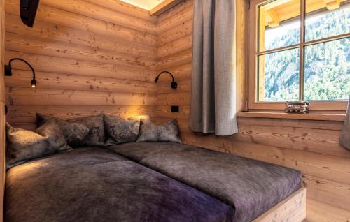 a bed in a wooden room with a window at Ferienhaus Großarl Mit Sauna in Grossarl