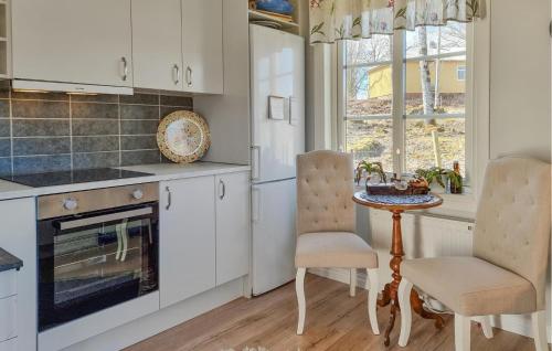 a kitchen with white cabinets and a table and chairs at Nice Home In Ulricehamn With Wifi in Ulricehamn