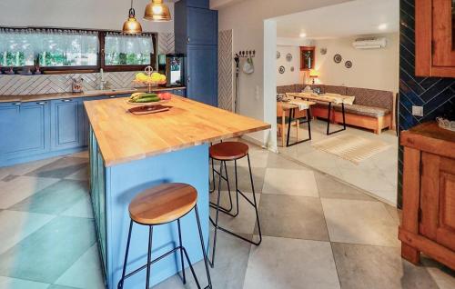 a kitchen with blue cabinets and a counter with stools at Pet Friendly Home In Sulów in Sułów