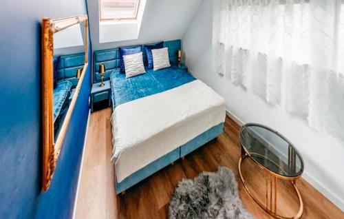 a blue bedroom with a bed and a mirror at Pet Friendly Home In Sulów in Sułów
