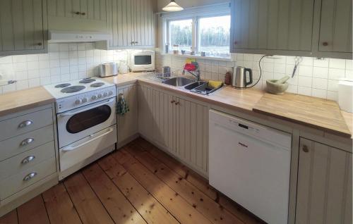 Una cocina con una estufa blanca y un fregadero. en Lovely Home In Ljungby, en Ljungby