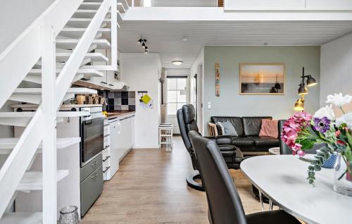 a kitchen and living room with a dining table and a staircase at Amazing Home In Vestervig With Sauna in Vestervig