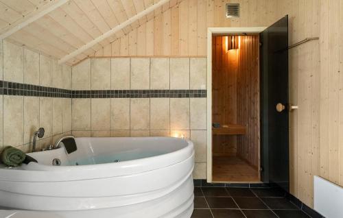 a large white tub in a bathroom with a door at Gorgeous Home In Vinderup With Sauna in Vinderup