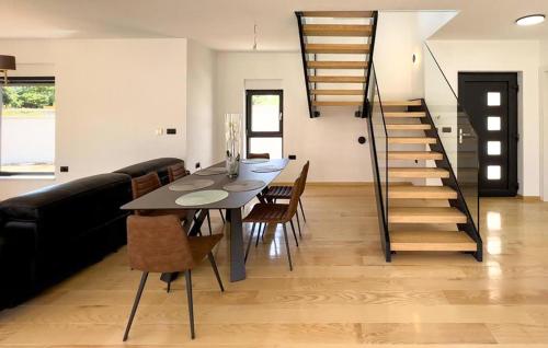 une salle à manger avec une table et des chaises et un escalier dans l'établissement Amazing Home In Liznjan, à Ližnjan