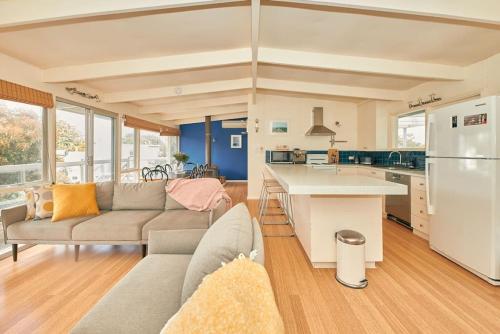 a living room with a couch and a kitchen at The Blue House - 200m from Point Roadknight Beach in Anglesea