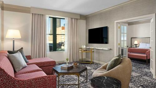 a living room with red furniture and a flat screen tv at Omni Severin Hotel in Indianapolis
