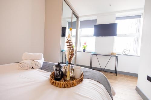 a white bedroom with a bed with a tray on it at New London 2 Bedroom, 2 Bathroom Flat in Finchley