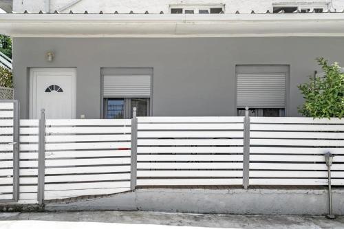 a white fence in front of a white house at Papatsas Center Houses in Nydri