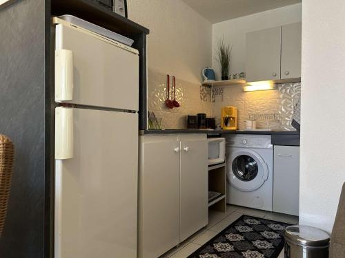 Il comprend une cuisine équipée d'un réfrigérateur et d'un lave-linge/sèche-linge. dans l'établissement Appartement cosy, 2 pièces, proche plage et parking sécurisé - FR-1-229D-150, à Fleury