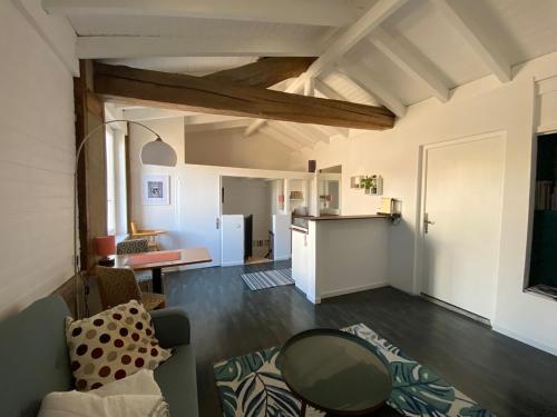 un salon avec un canapé et une table et une cuisine dans l'établissement Appartement cosy à Eymet, à Eymet
