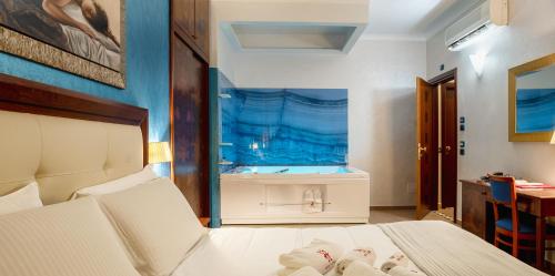 a bedroom with a bed and an aquarium in the background at Hotel Flora in Noto