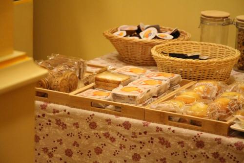 a table topped with trays of pastries and baskets at Hotel Matteotti in Vercelli