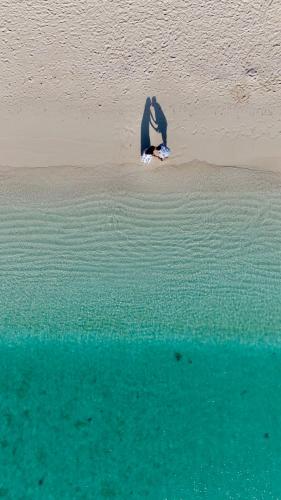 a shadow of a person on the beach at Atoll Retreat in Fulidhoo