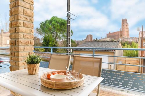 une corbeille de fruits sur une table sur un balcon dans l'établissement La passerelle - vue et proximité cathédrale, terrasse, parking privé, à Albi
