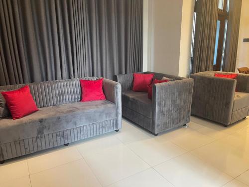 a living room with two couches and red pillows at Royal Palace Mirissa in Mirissa