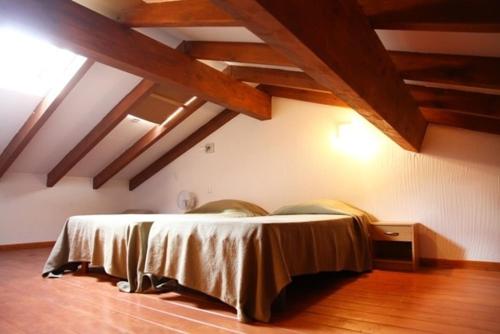 une chambre avec un lit dans une pièce avec des plafonds en bois dans l'établissement Minivilla Figari vue mer, plage Santa Giulia, à Porto-Vecchio