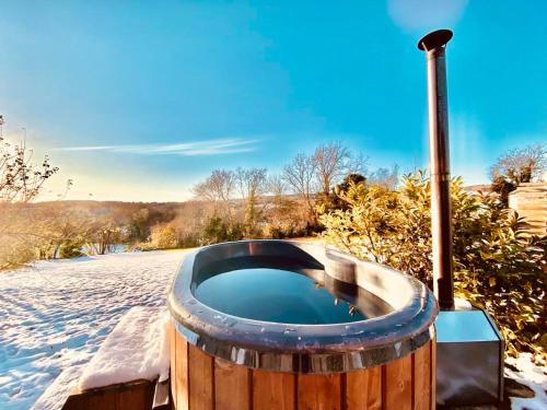 a wooden barrel with a hot tub in the snow at Off-Grid Glamping - Quiet, Starry Escape in Yarpole