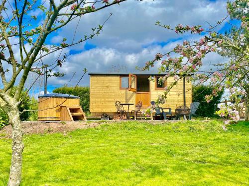 a tiny house in a garden with a picnic table at Off-Grid Glamping - Quiet, Starry Escape in Yarpole