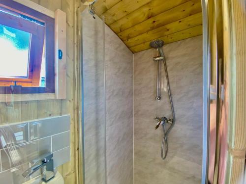 a shower with a shower head in a bathroom at Off-Grid Glamping - Quiet, Starry Escape in Yarpole