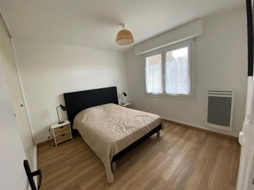 une chambre blanche avec un lit et une fenêtre dans l'établissement Charmant appartement résidence Haute Mer, à Fort-Mahon-Plage