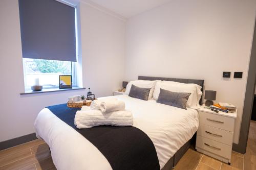a bedroom with a bed with white sheets and a window at Chic 2King BD Apt London with Ensuite & Pull Out Bed in Finchley