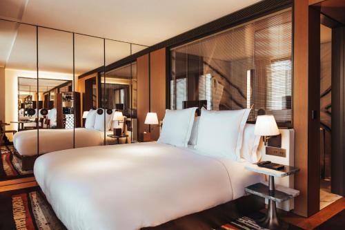 a large white bed in a room with mirrors at Hotel SAX Paris, LXR Hotels & Resorts in Paris