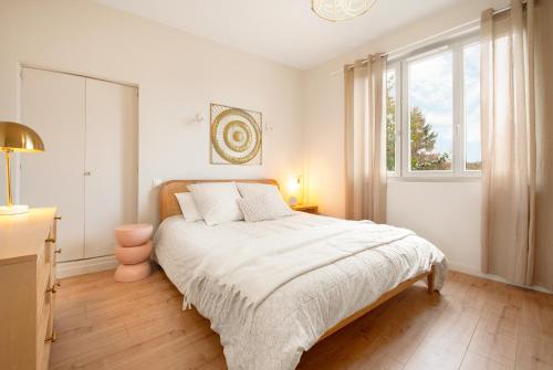 une chambre blanche avec un lit et une fenêtre dans l'établissement La passerelle - vue et proximité cathédrale, terrasse, parking privé, à Albi