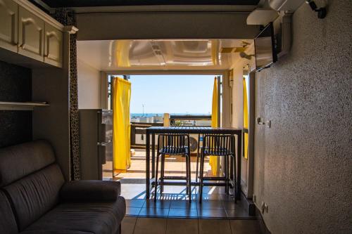 un salon avec une table, des chaises et un canapé dans l'établissement CapNat - Village Naturiste - Port Nature - Le Macumba, au Cap d'Agde