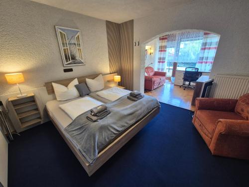 a bedroom with a large bed and a living room at Hotel Schönblick in Bad Herrenalb