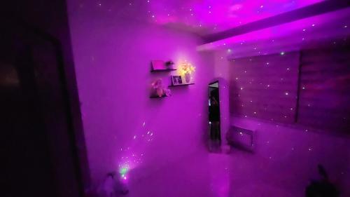 Una habitación morada con un espejo y luces moradas. en Anna's cozy house, en Ángeles