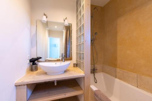 La salle de bains est pourvue d'un lavabo et d'une baignoire. dans l'établissement Parenthèse enchantée, mas de caractère, grande piscine, parc paysagé aux portes de Montpellier et des plages, à Mauguio