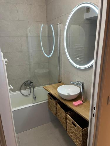une salle de bain avec un lavabo et une douche avec un miroir dans l'établissement Magnifique studio Megève, à Megève