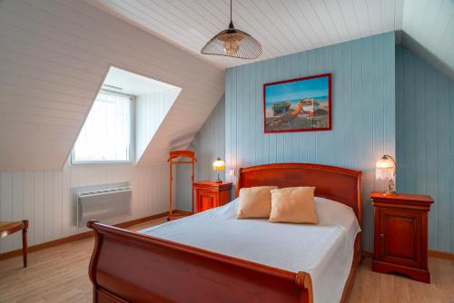 une chambre avec un lit aux murs bleus et une fenêtre dans l'établissement La Familiale proche mer, à Plouhinec