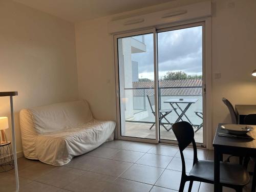 - un salon avec un lit et une vue sur un balcon dans l'établissement Appartement 2 pièces LR340-D101, à La Rochelle