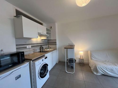 - une cuisine avec lave-linge et un lit dans une chambre dans l'établissement Appartement 2 pièces LR340-D101, à La Rochelle