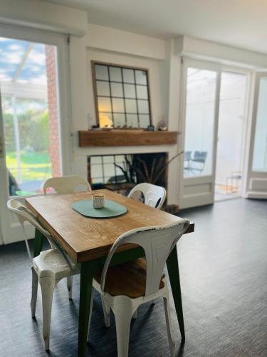 - une table et des chaises dans une pièce dotée d'une cheminée dans l'établissement Maison des Pins - Jardin, calme et plage - Lock'inn, à Saint-Palais-sur-Mer