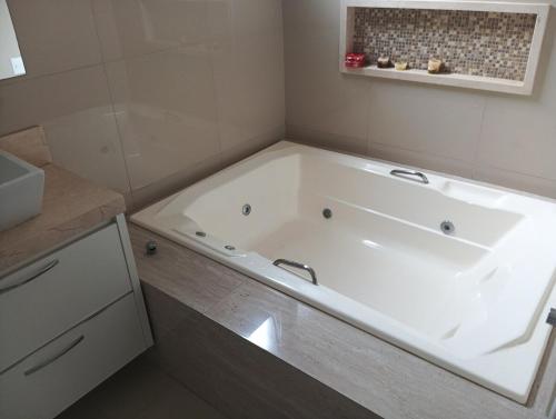 a large white bath tub in a bathroom at casa espaçosa e confortável in Sao Jose do Rio Preto