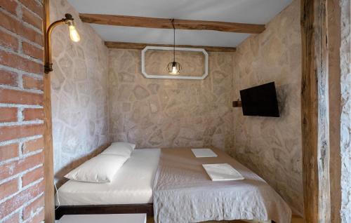 a small room with a bed in a brick wall at 2 Bedroom Amazing Home In Pirovac in Pirovac