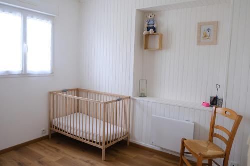 une chambre avec un lit bébé, une chaise et une fenêtre dans l'établissement Evasion Marine, Cozy home, à Criel-sur-Mer