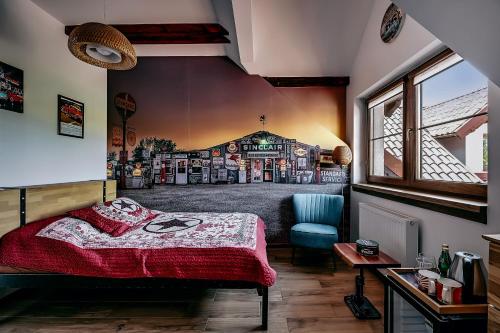a bedroom with a bed and a chair in a room at Jantarvia Car Museum , Pasja i Wypoczynek Noclegi z Klimatem in Jantar